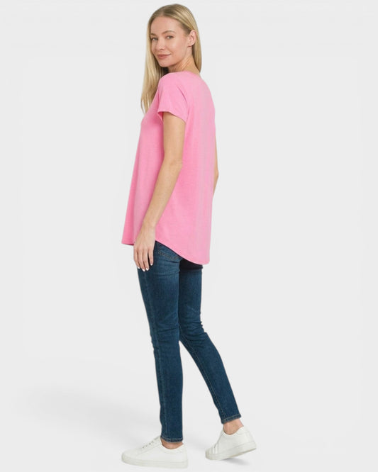 Woman wearing a pink t-shirt and blue jeans on a white background