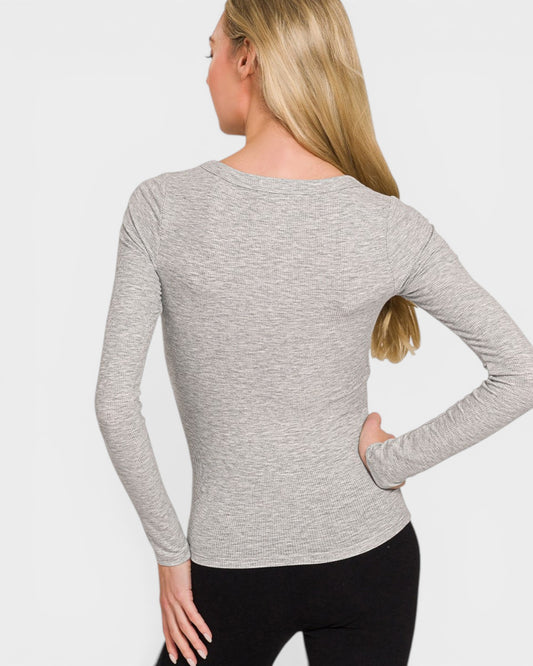 Woman wearing a gray long-sleeve top on a white background