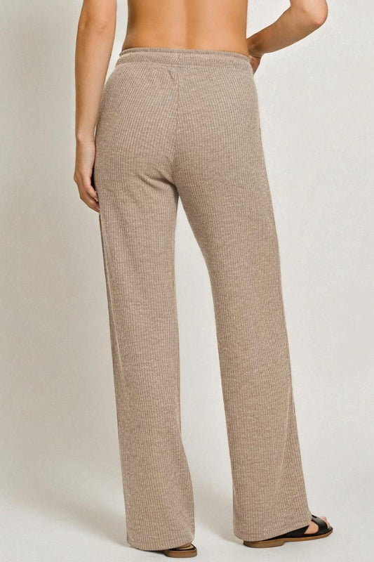 Beige ribbed pants worn by a person on a plain background