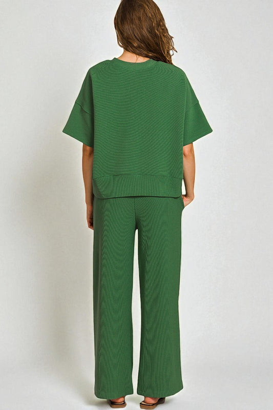 Person wearing a green textured outfit on a white background