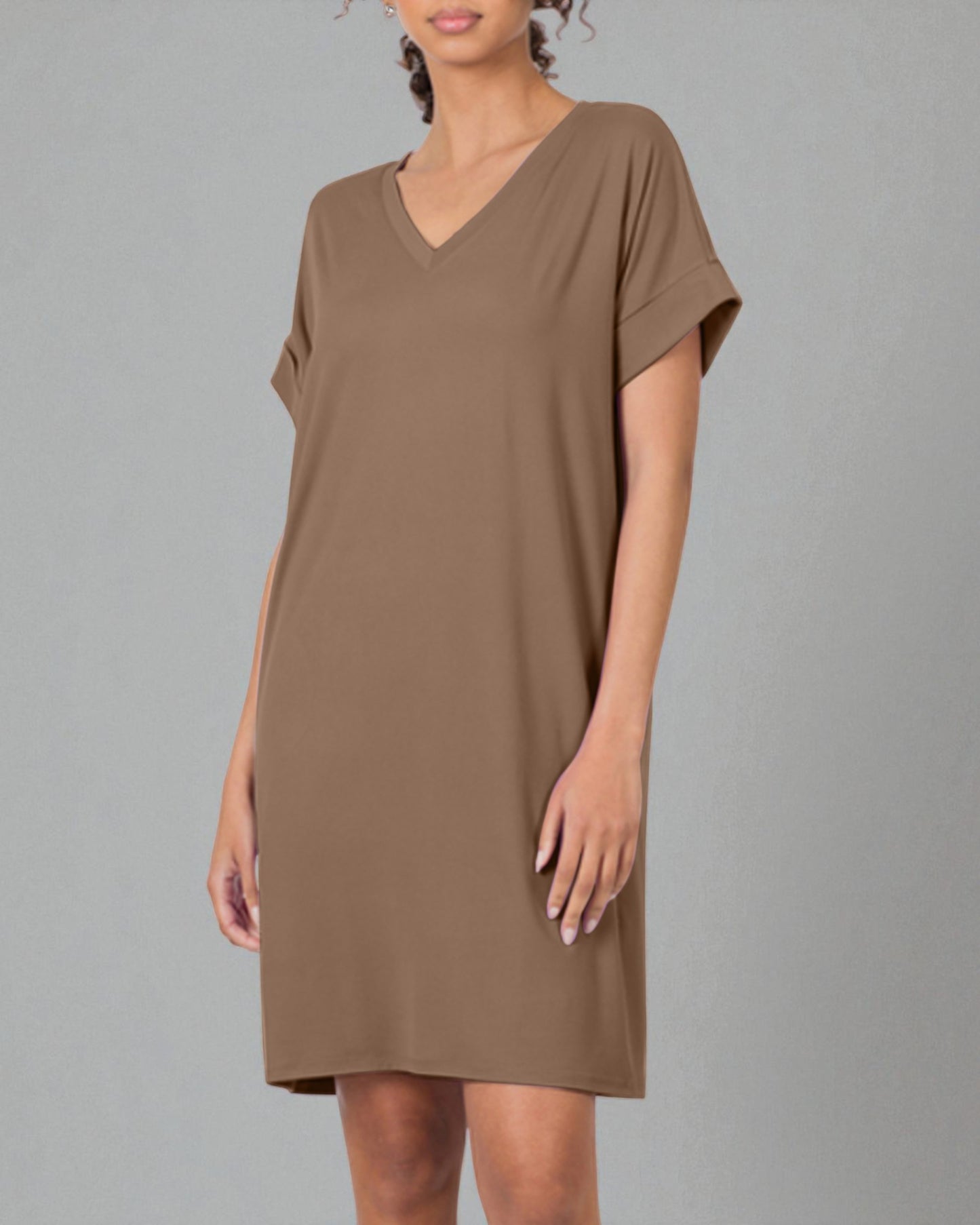 Woman wearing a brown dress against a gray background
