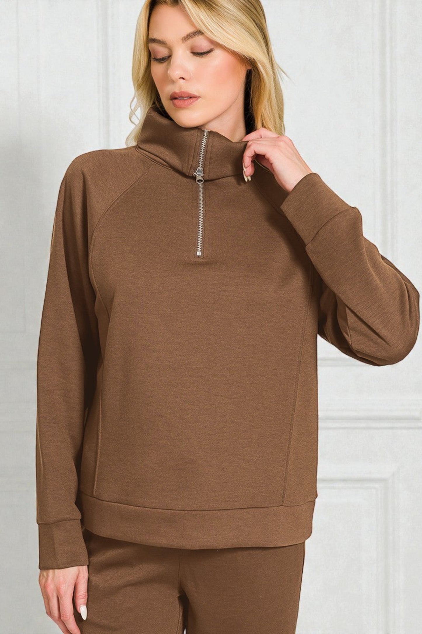Woman wearing a brown hoodie with a zipper on a white background