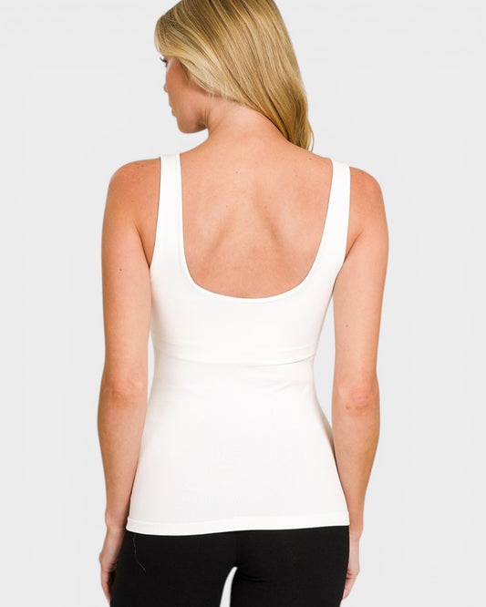 Woman wearing a white tank top on a plain background