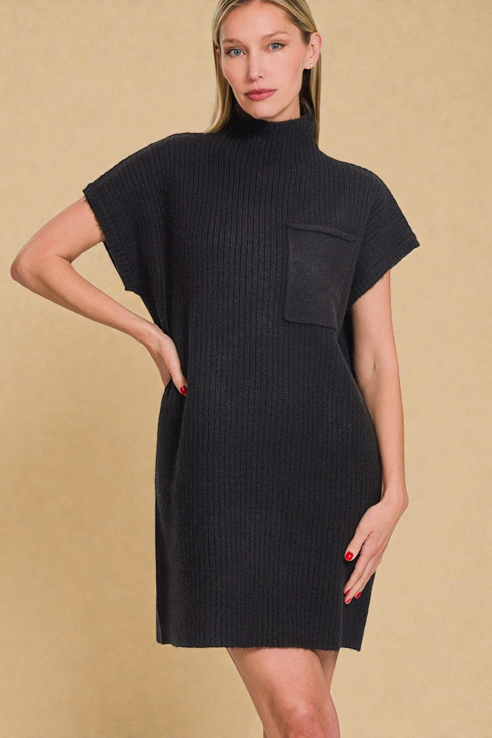 Woman wearing a black dress with a pocket against a beige background