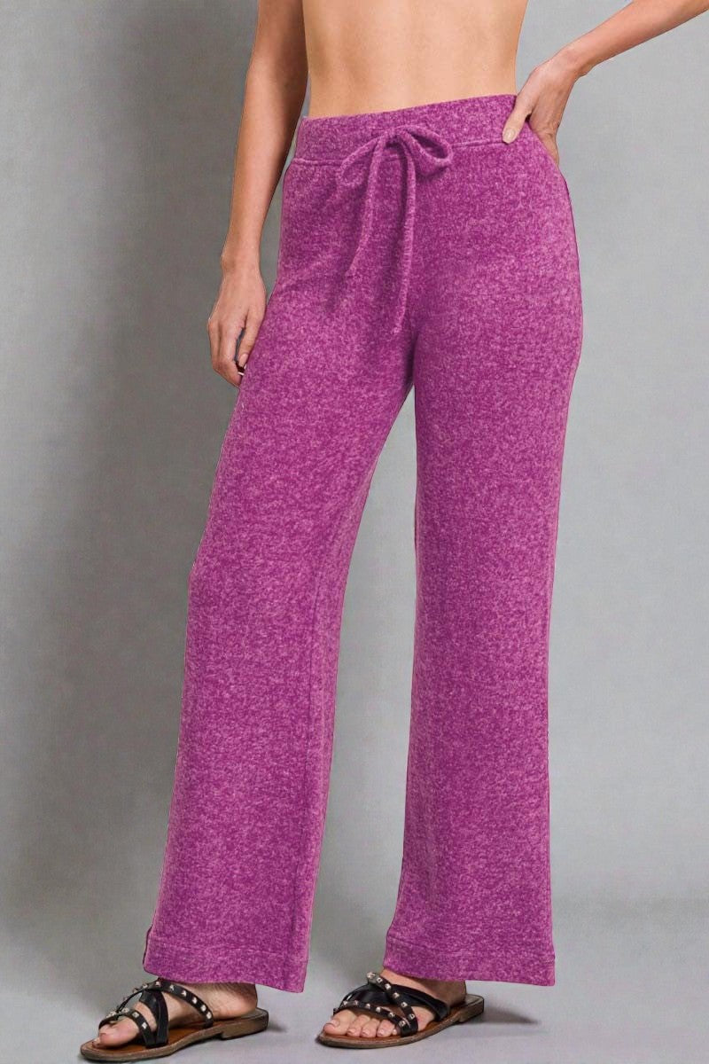 Person wearing purple pants on a gray background