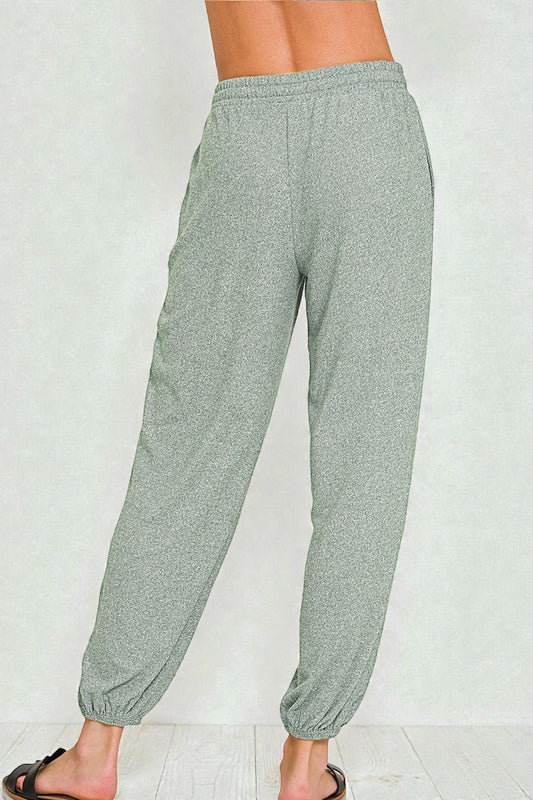 Light gray jogger pants worn by a person on a white background