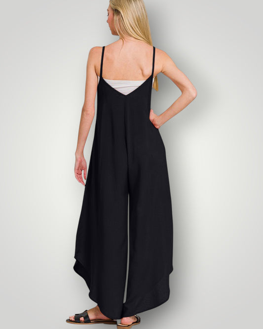 Woman wearing a black slip dress on a plain background