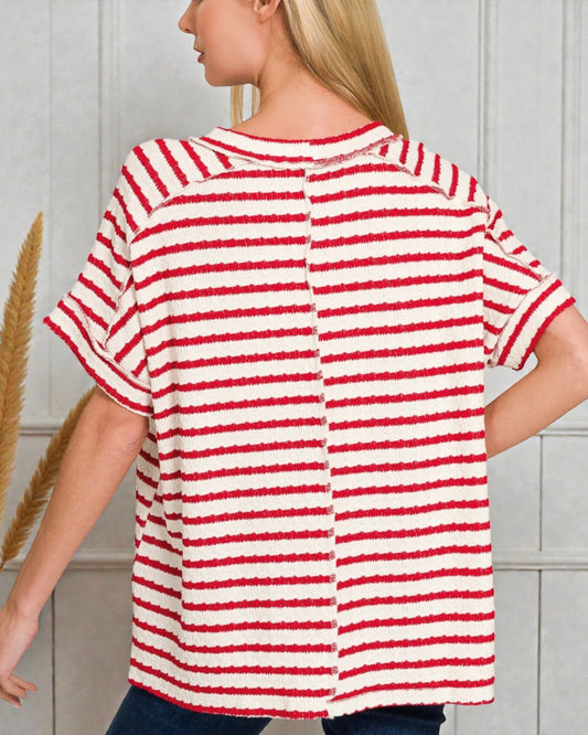 Woman wearing a red and white striped shirt against a neutral background