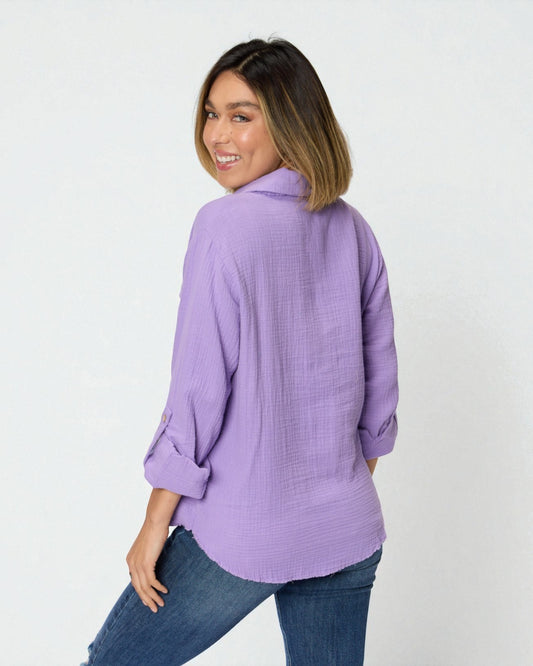 Woman wearing a purple shirt and blue jeans on a white background