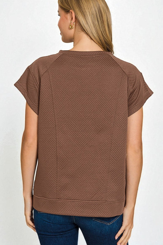 Brown textured top worn by a person on a white background