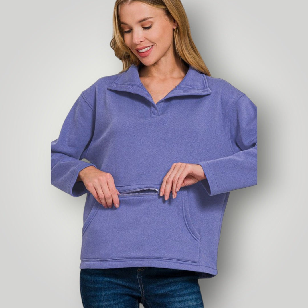 Woman wearing a purple pullover with a zipper on a light gray background