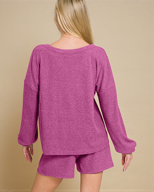 Person wearing a purple sweater and shorts set on a beige background
