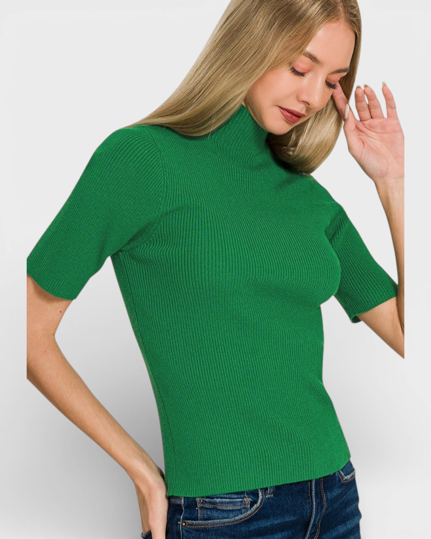 Woman wearing a green ribbed top against a white background