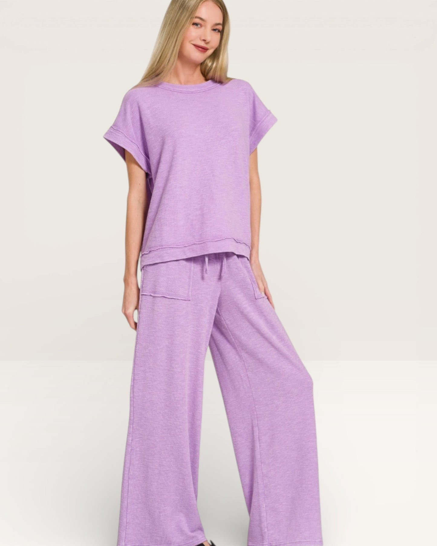 Woman wearing a purple outfit on a plain background