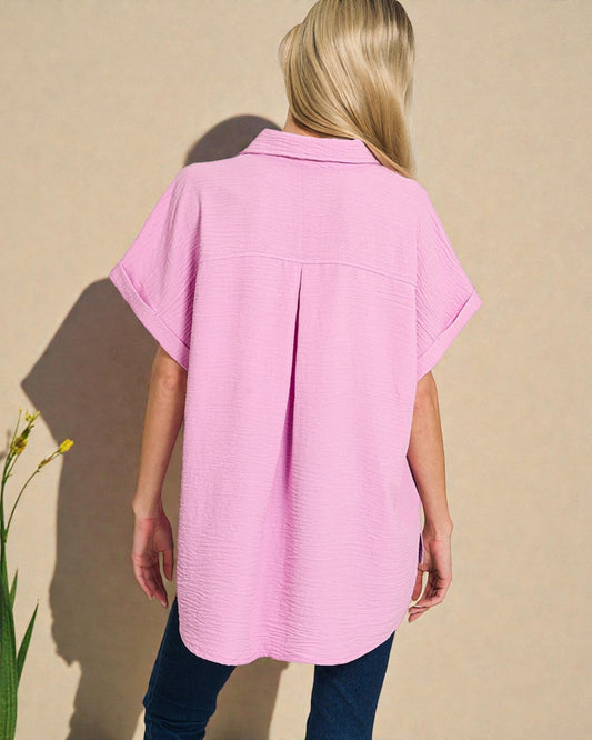 Person wearing a pink shirt against a beige background