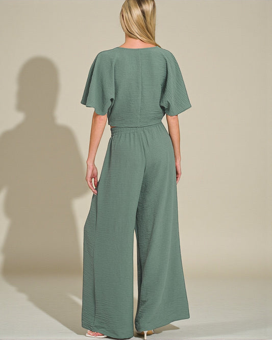 Woman wearing a green jumpsuit against a plain background