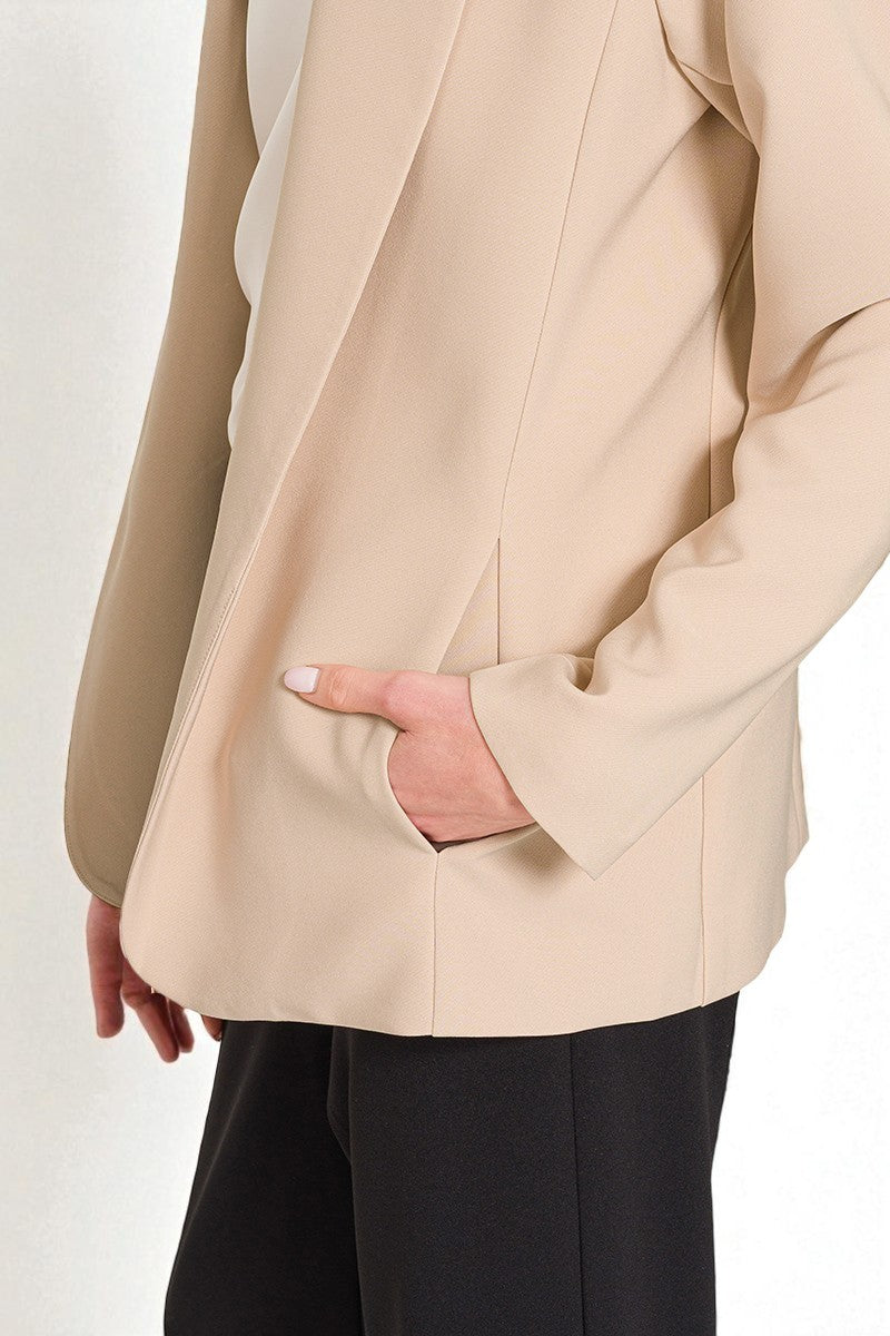 Beige blazer worn by a person on a white background