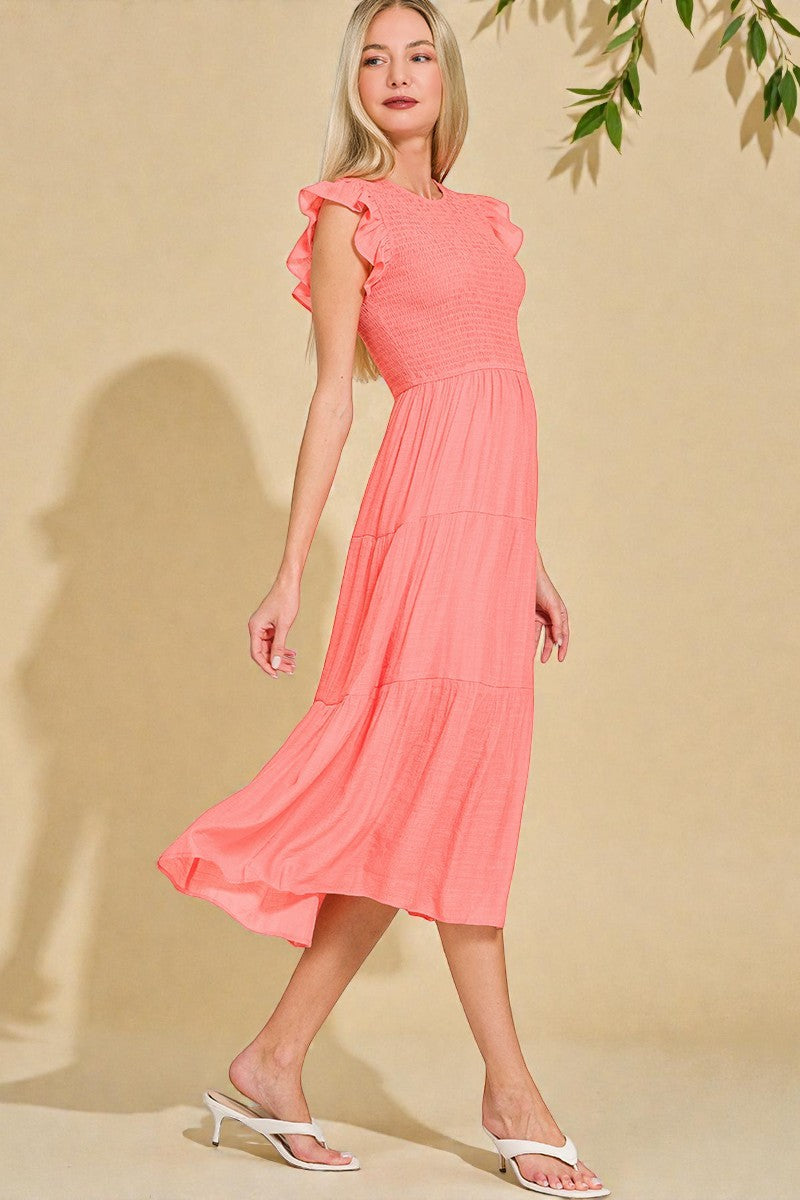 Woman wearing a coral dress against a beige background