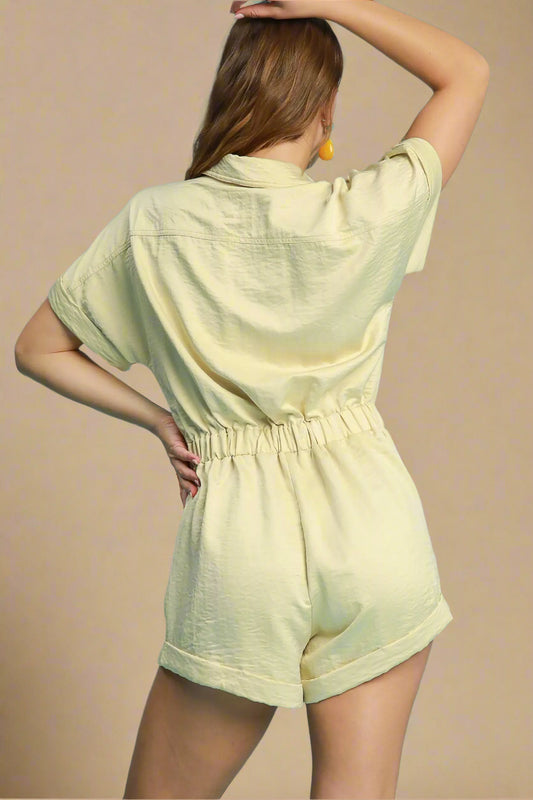 Woman wearing a light yellow romper against a solid background