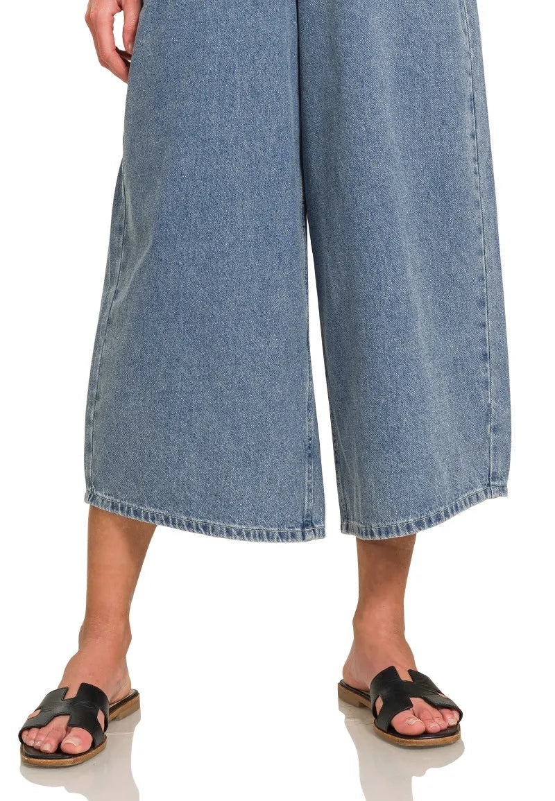 Denim wide-leg pants worn by a person on a white background