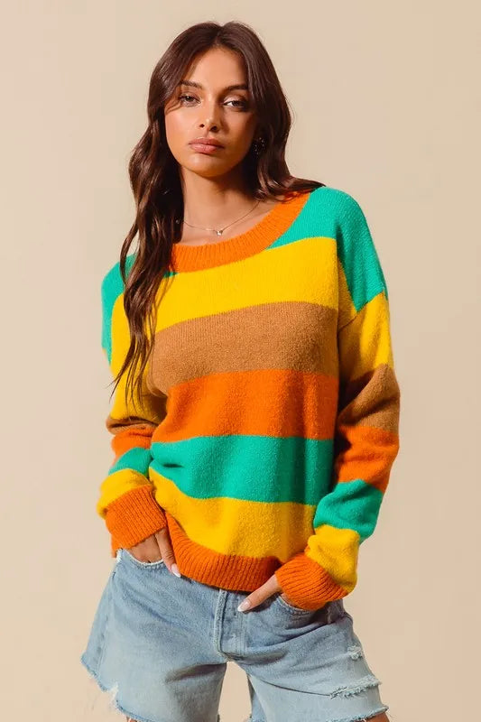 Woman wearing a colorful striped sweater against a beige background