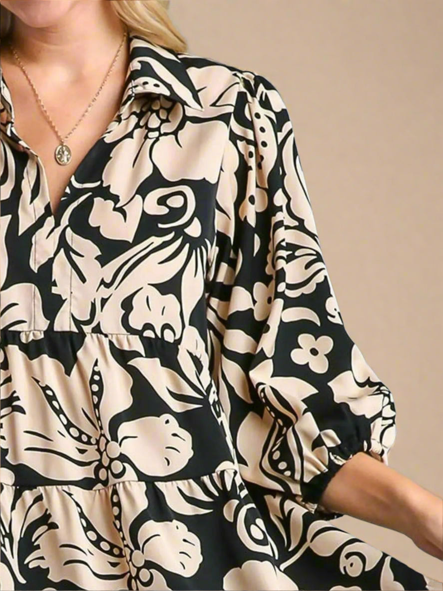 Woman wearing a black and beige patterned dress against a beige background