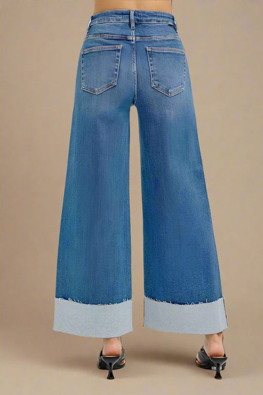 Blue wide-leg jeans on a beige background