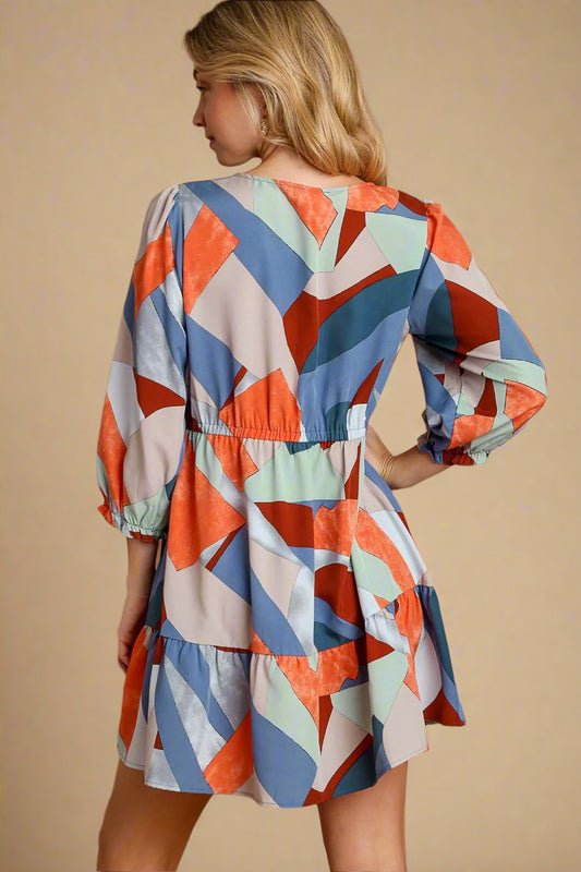 Woman wearing a colorful geometric patterned dress on a beige background