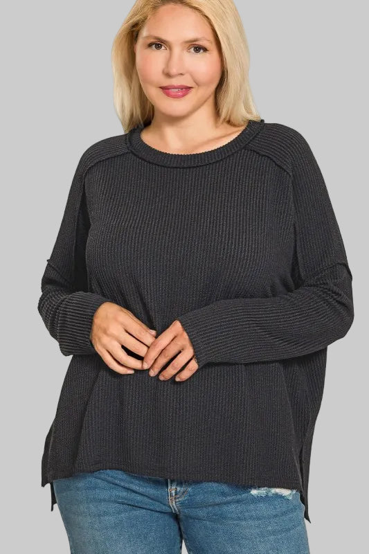 Woman wearing a black sweater with a plain background