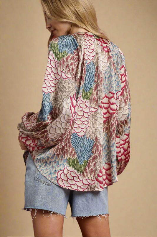 Person wearing a patterned shirt with denim shorts on a red background