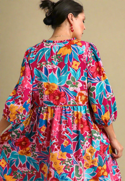 Woman wearing a colorful floral dress with a gray background