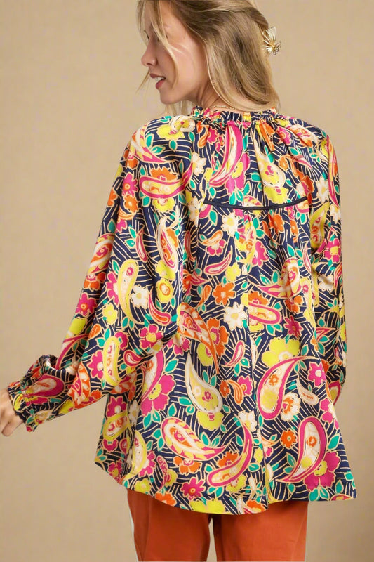 Woman wearing a colorful patterned jacket on a plain background