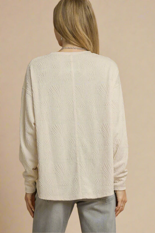 Woman wearing a beige sweater against a beige background