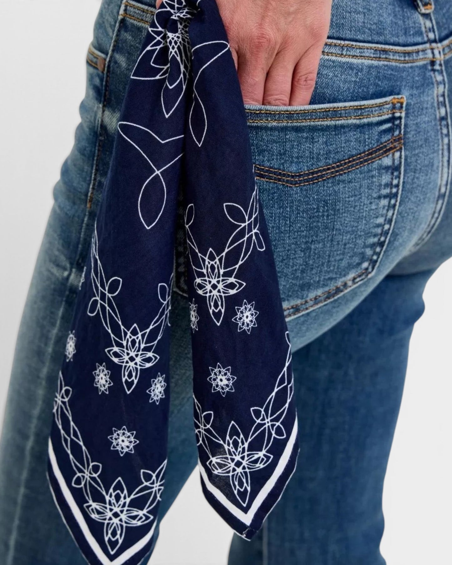 Beach Rose Co. dark wash denim flare jeans with a navy bandana accent featuring white floral and swirl print.