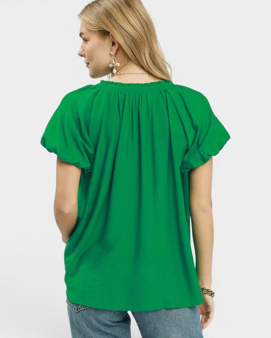 Beach Rose Co. green textured woven rayon-nylon blend blouse with ruffled V-neckline and puff sleeves.