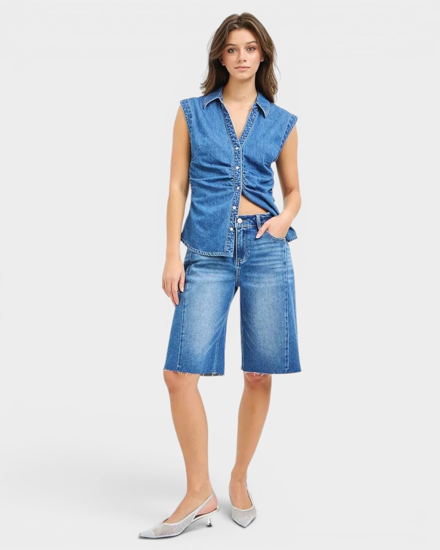 Beach Rose Co. Medium wash denim Bermuda shorts with raw hem, five-pocket styling, and stretch fabric.