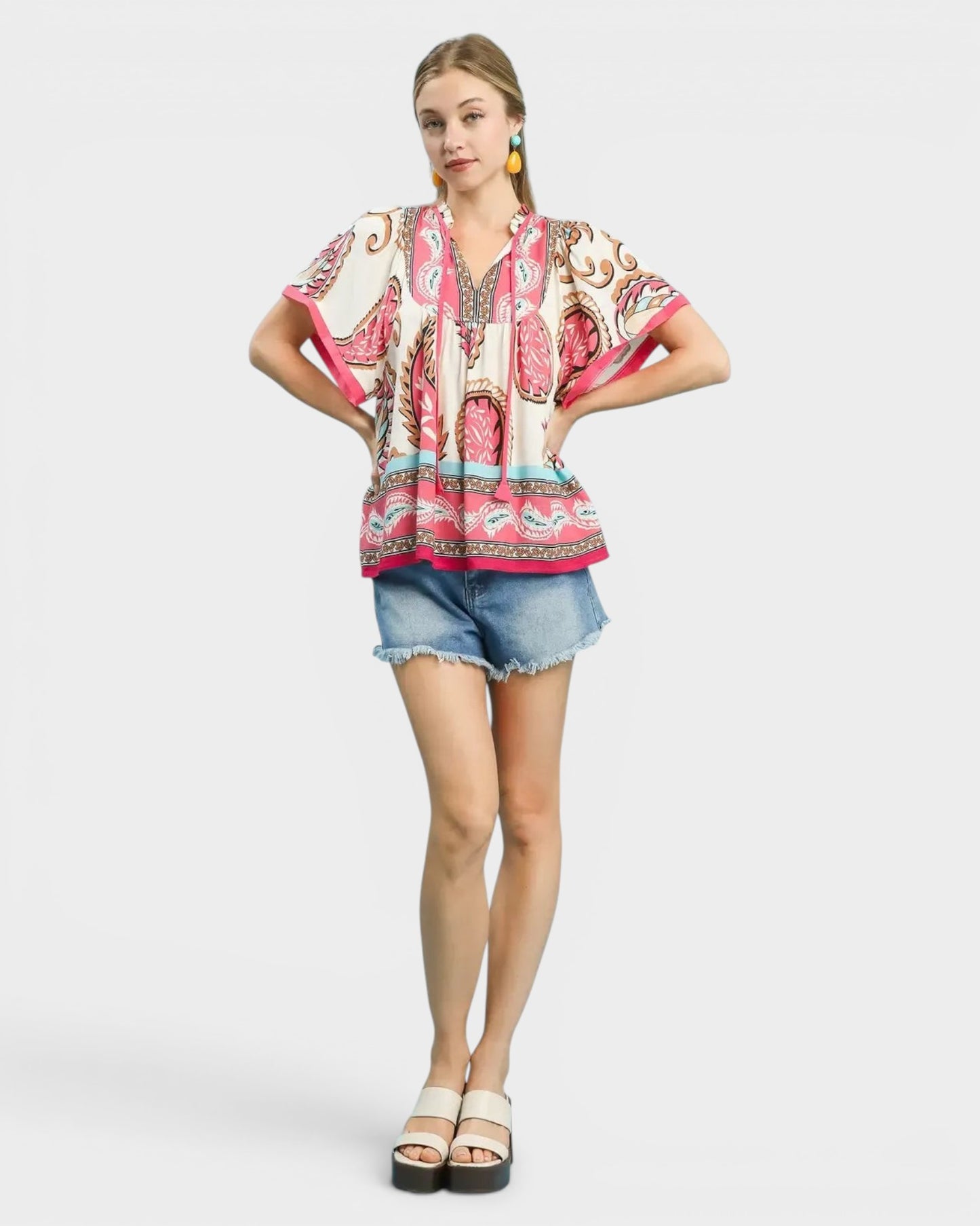 Beach Rose Co. ivory rayon top with pink, tan, and blue paisley border print, split neckline, and tie detail.