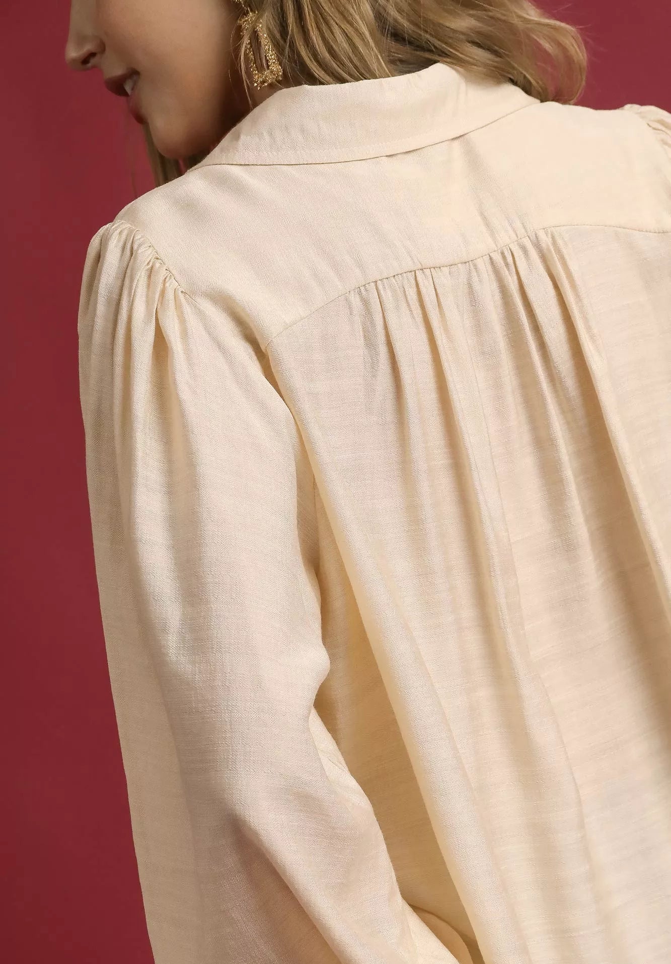 Beige blouse with long sleeves on a red background