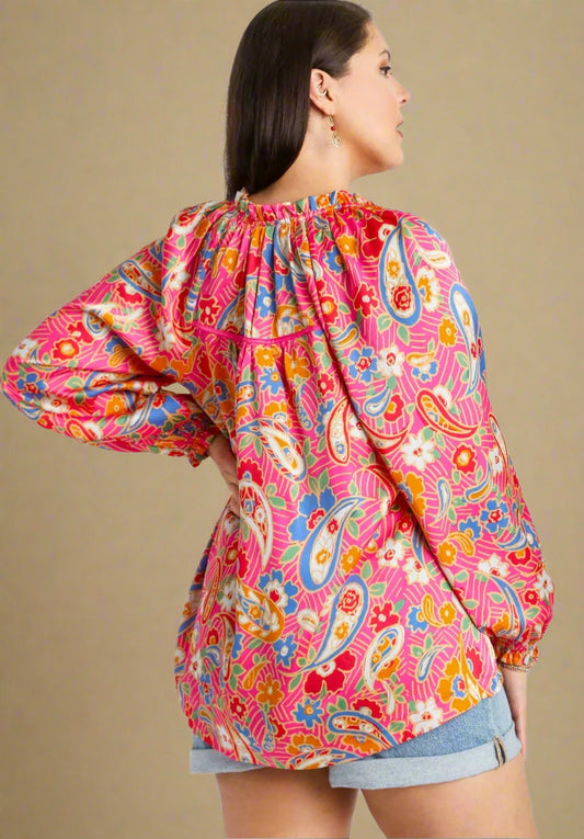 Woman wearing a colorful paisley patterned jacket on a beige background