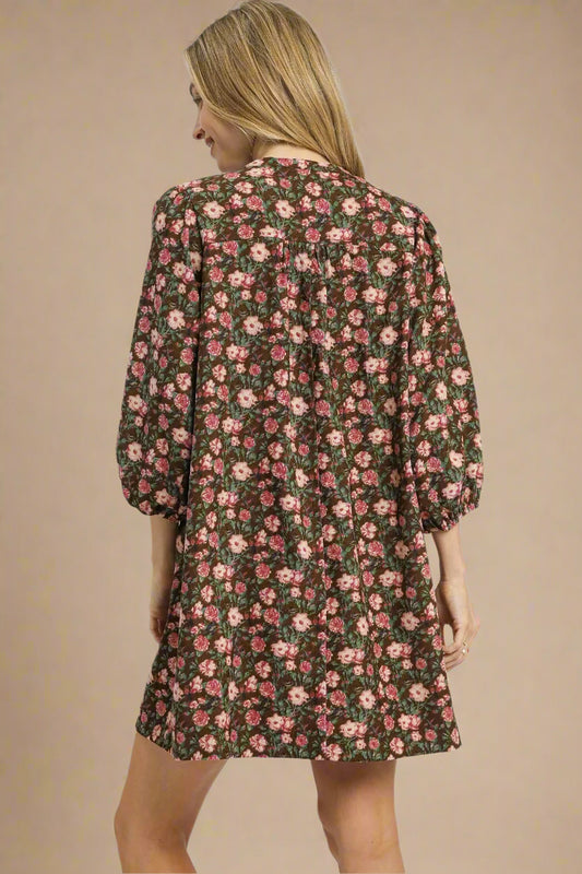 Woman wearing a floral dress with brown and pink pattern on a white background