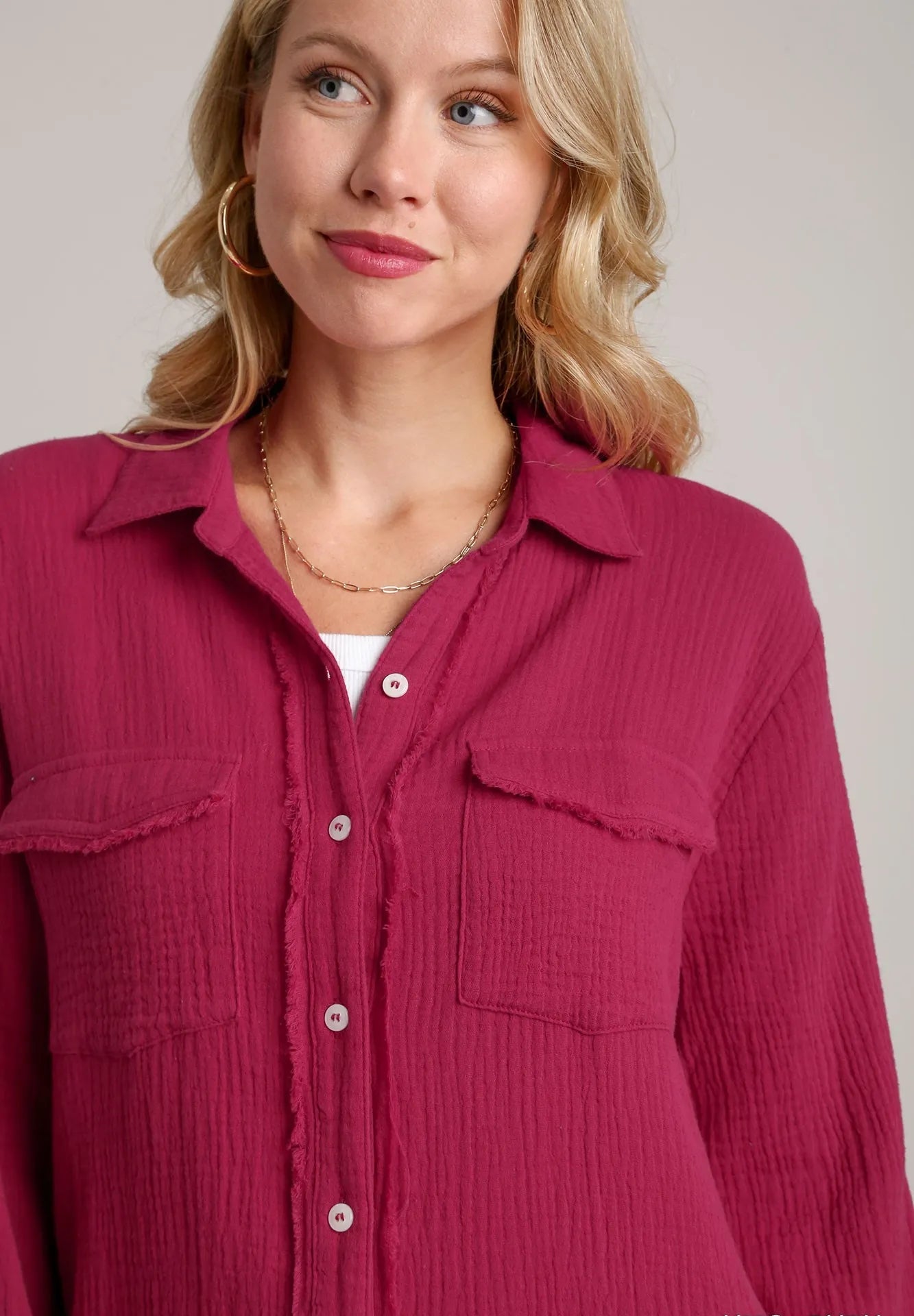 Woman wearing a pink shirt with a plain background