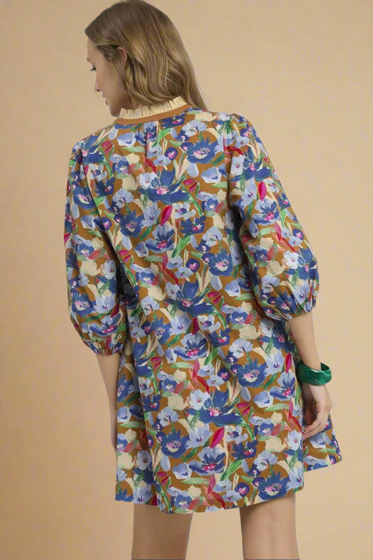 Woman wearing a colorful floral dress on a beige background