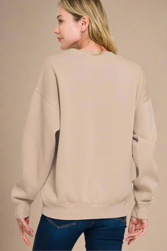 Person wearing a beige sweatshirt on a beige background