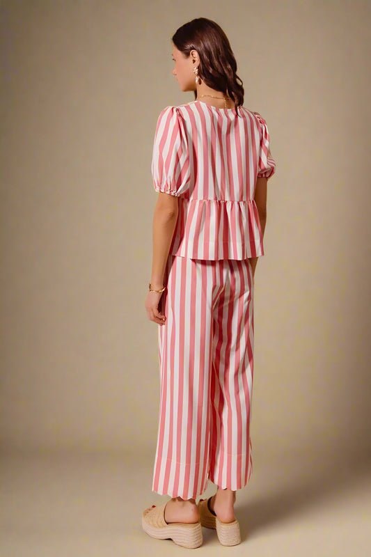 Woman wearing a red and white striped outfit on a beige background