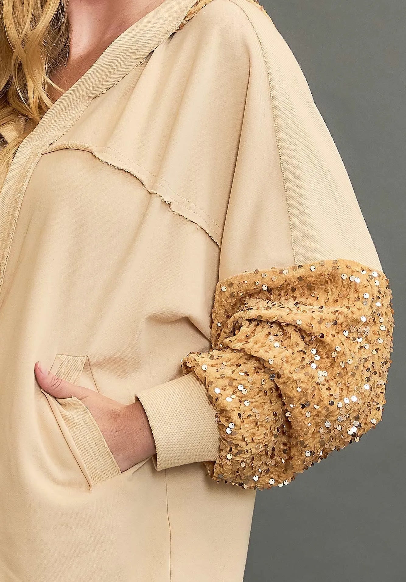 Beige outfit with sequin detail on a gray background
