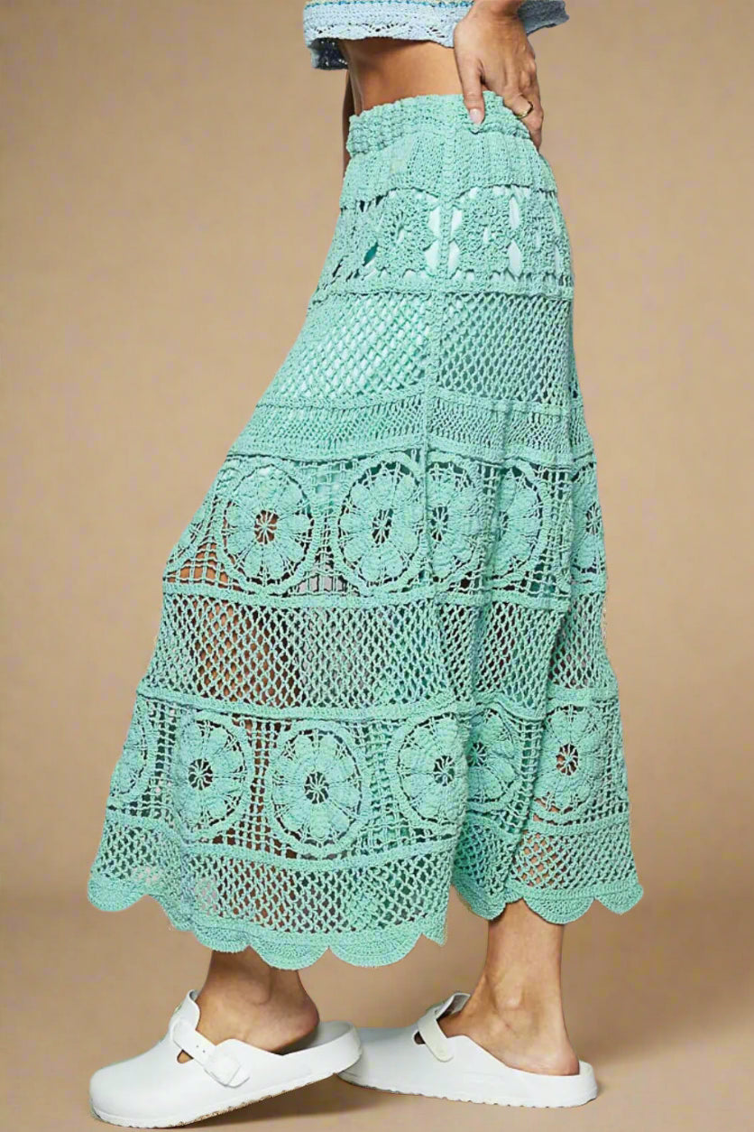 Mint green crochet skirt worn by a person on a plain background