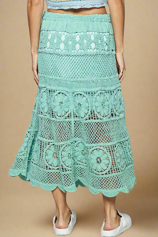 Mint green crochet skirt worn by a person on a plain background