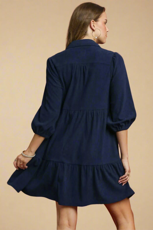 Woman wearing a navy blue dress against a beige background