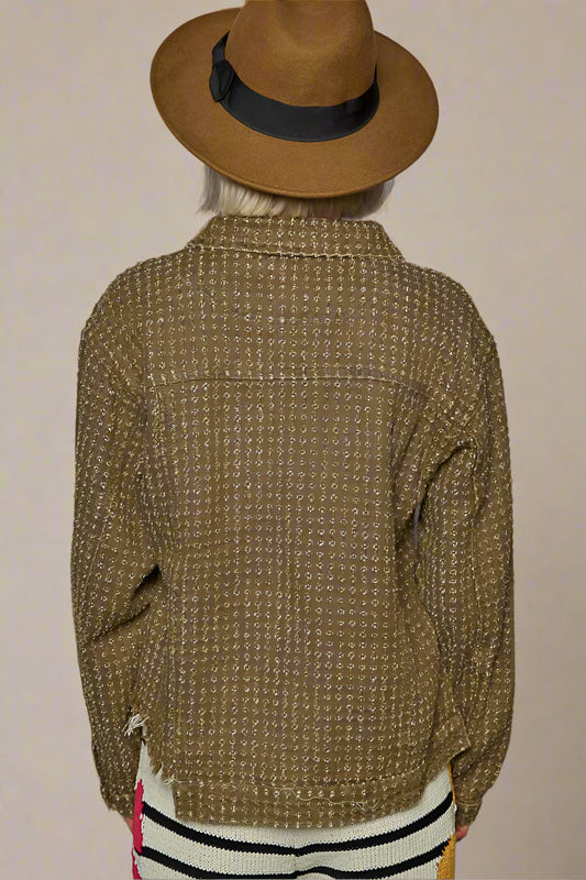 Person wearing a brown textured jacket and hat against a beige background