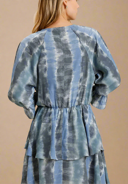 Blue and gray tie-dye dress with puffed sleeves on a beige background
